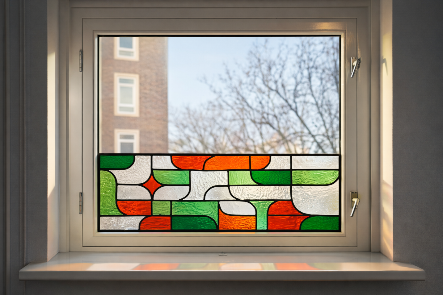 Maatwerk glas-in-lood voorzetraam in oranje en groene tinten